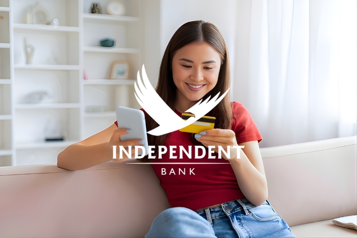 Independent Bank logo overlaid on an image of a girl using her phone to enter her card information