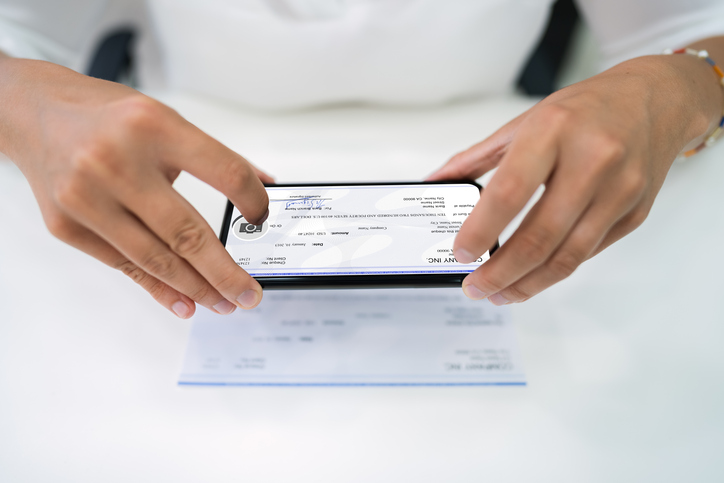 person taking a photo of a check