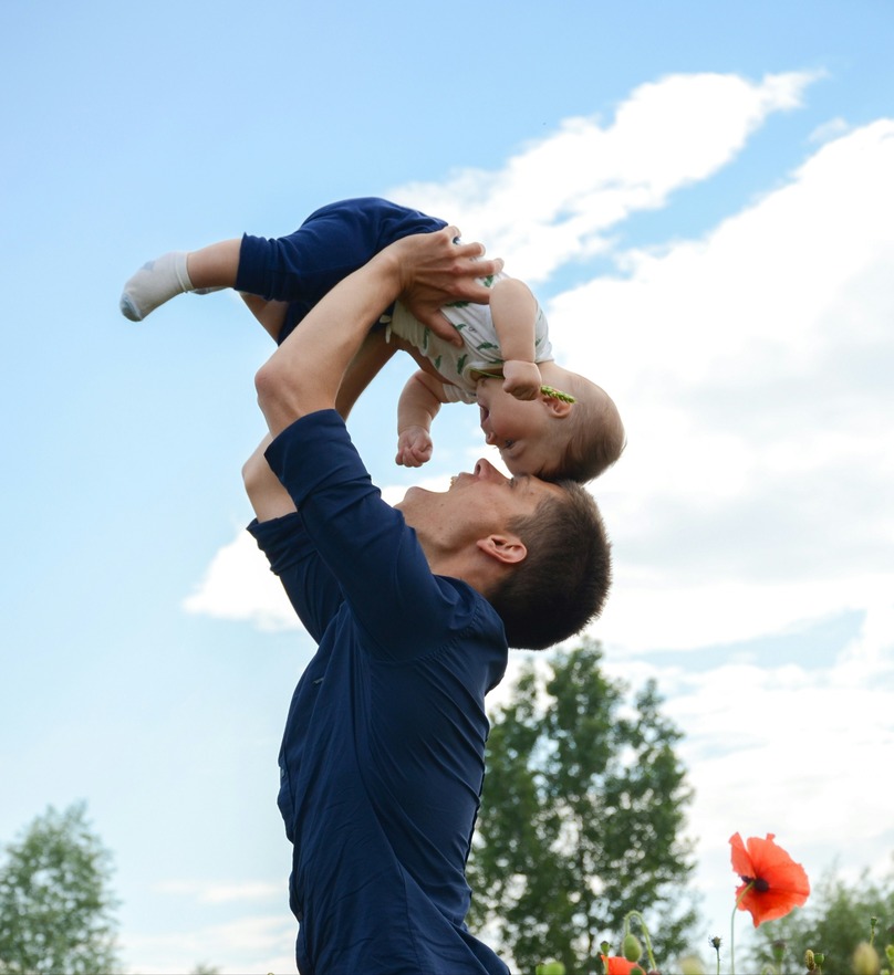 Man playing in a field with his son